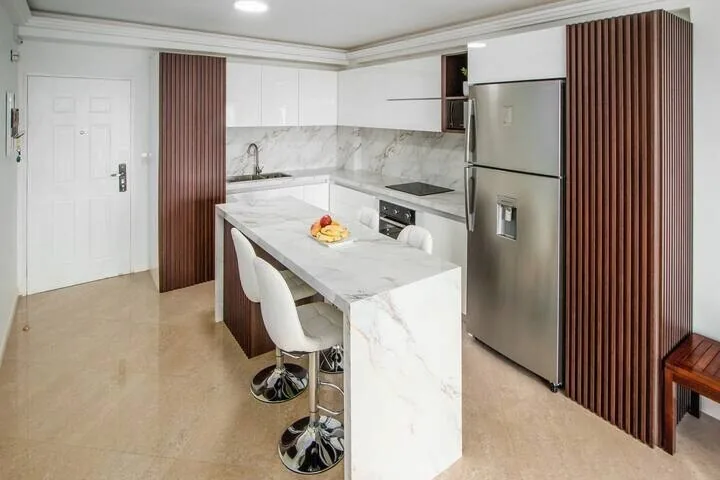 Cocina con nevera Whirlpool e isla con taburetes, apartamento en Pampatar