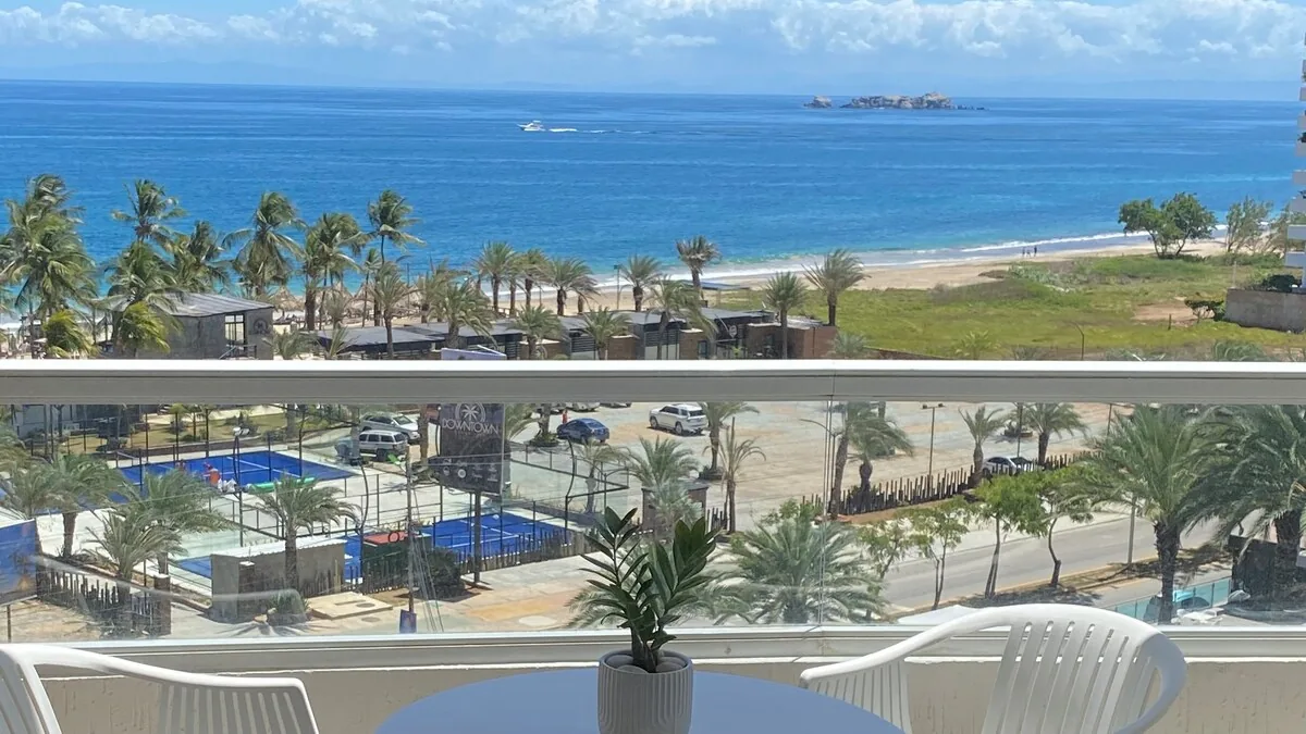 Vista del mar, la playa y las palmeras desde el balcón